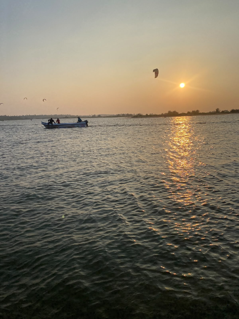 Sunset over the water at Donkey Point with a boat and kites in the sky