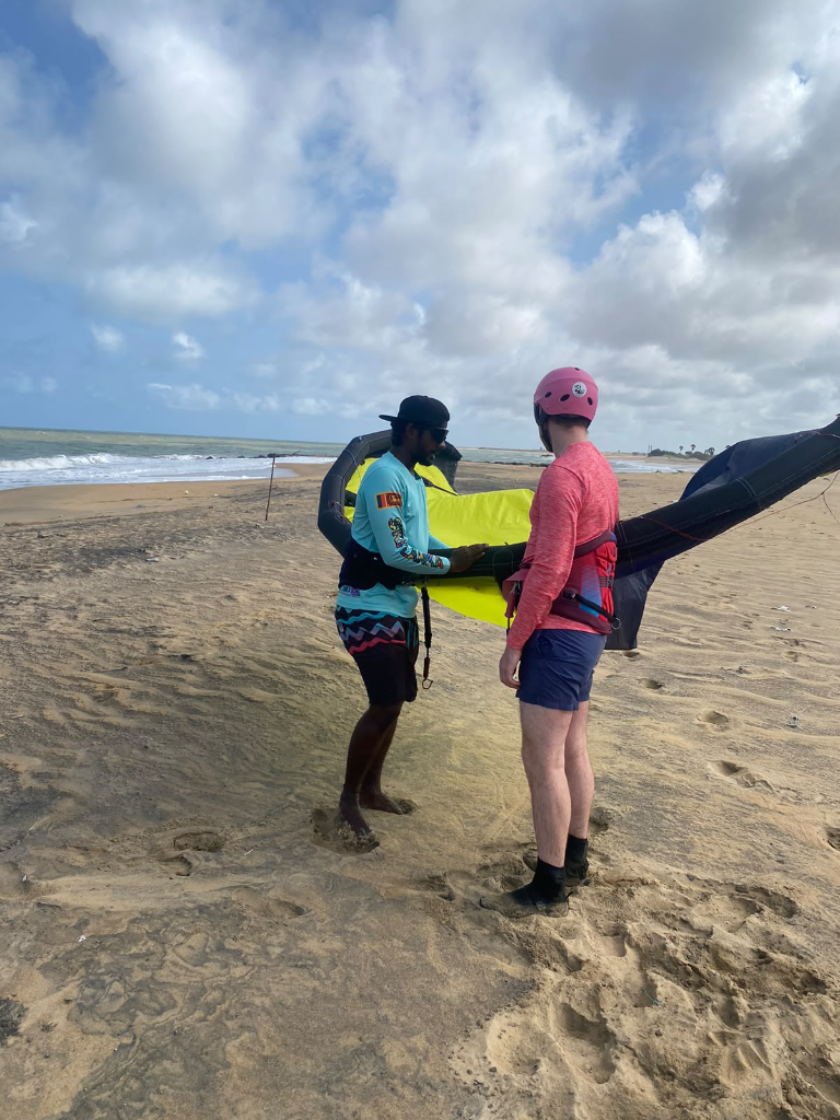 Kitesurfing instructor helping a rider prepare a kite at Dream Spot in Kalpitiya