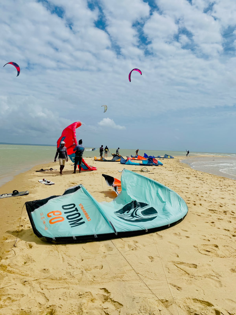 Kitesurfers and colorful kites on the sandy shore of Vella Island, Kalpitiya